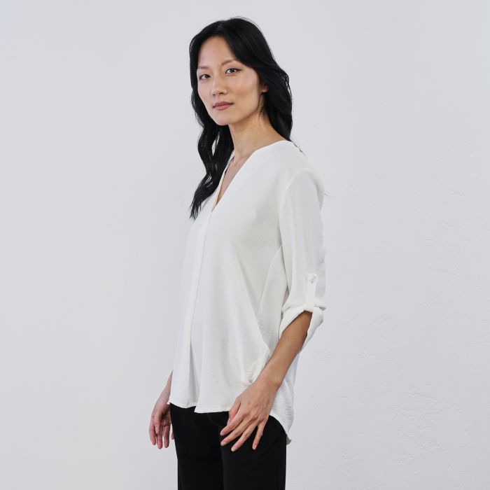 Blusa bianca da donna con scollo a V e maniche con bottone